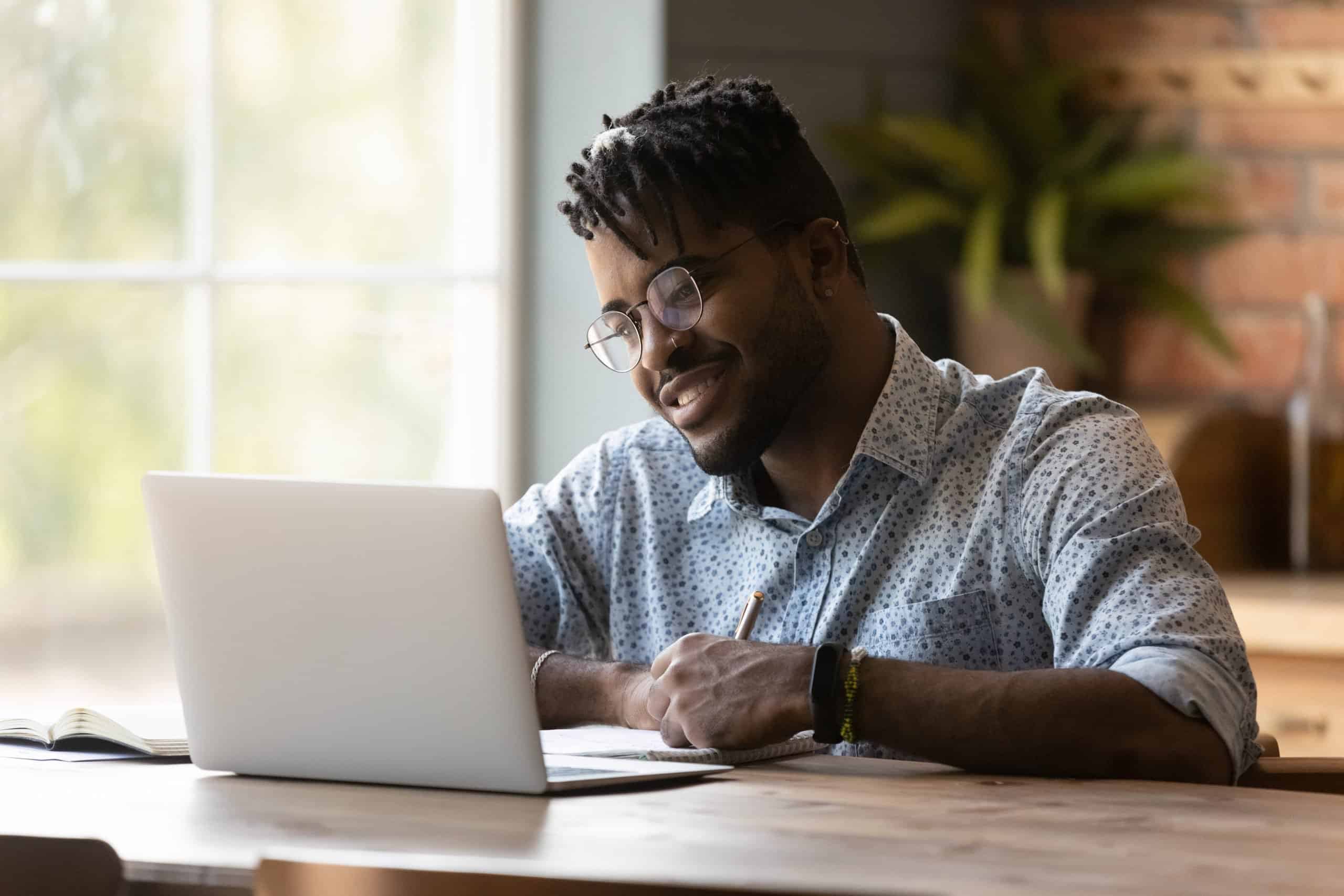 Close,Up,Smiling,African,American,Man,Wearing,Glasses,Using,Laptop,