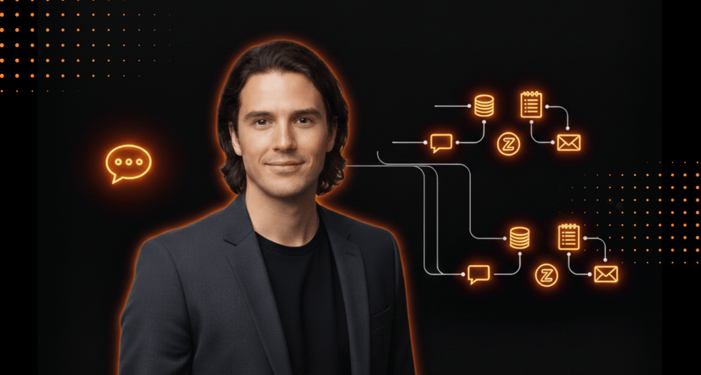 A man in a dark blazer stands in front of a black background with glowing orange icons representing data flow, communication, and messaging processes.